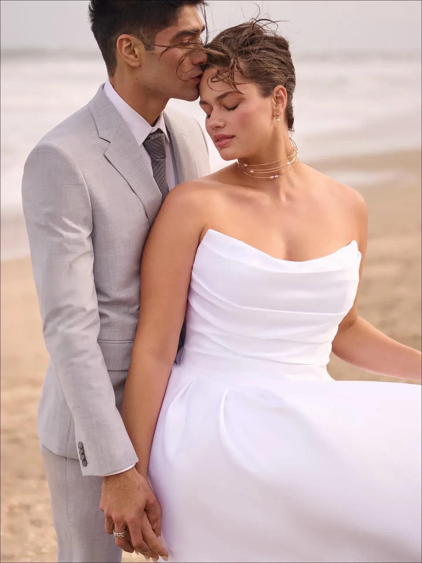 model is wearing a strapless plus size ball gown wedding dress