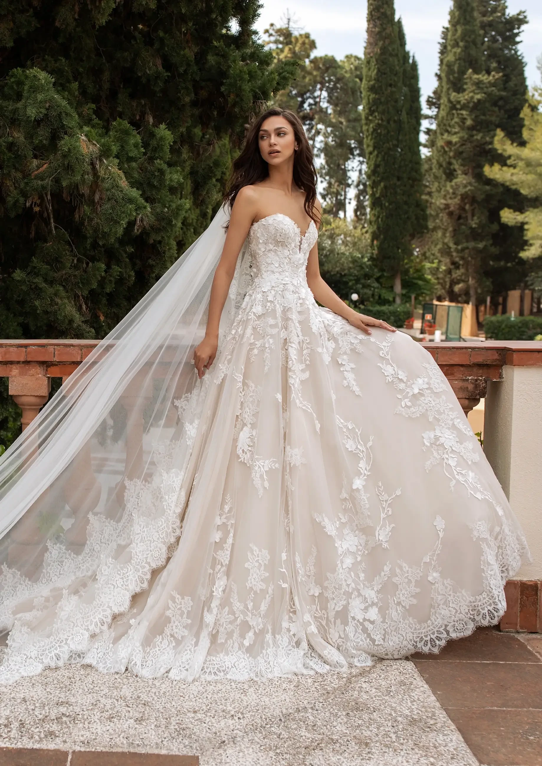 model is wearing a strapless lace wedding gown