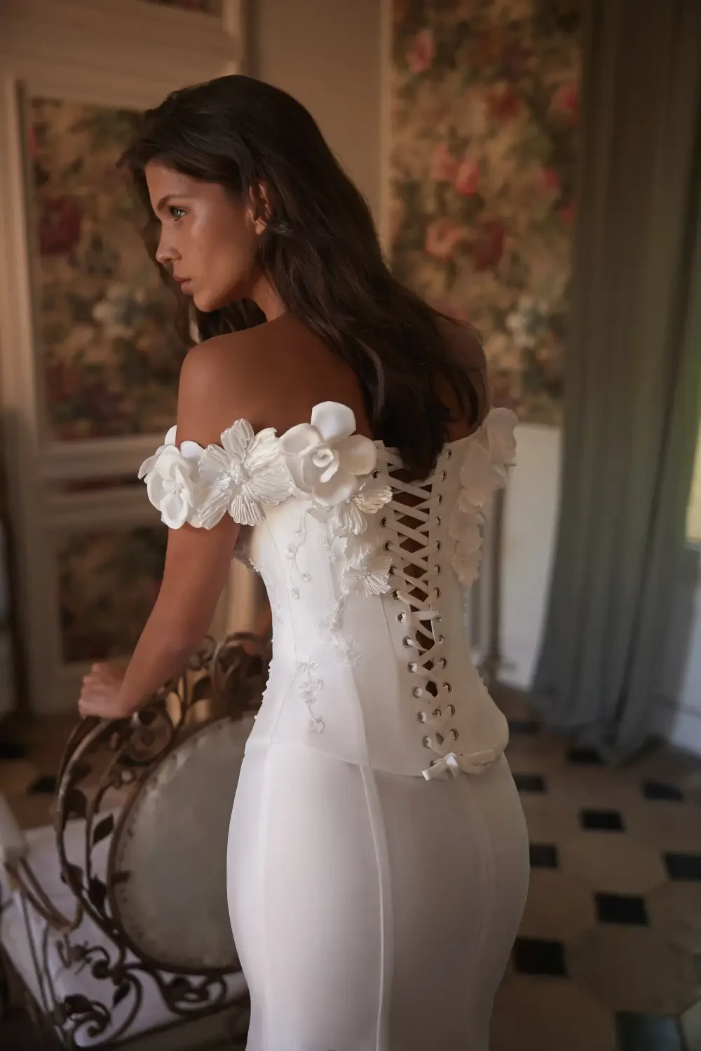 model is wearing an off the shoulder 3d floral applique bridal gown